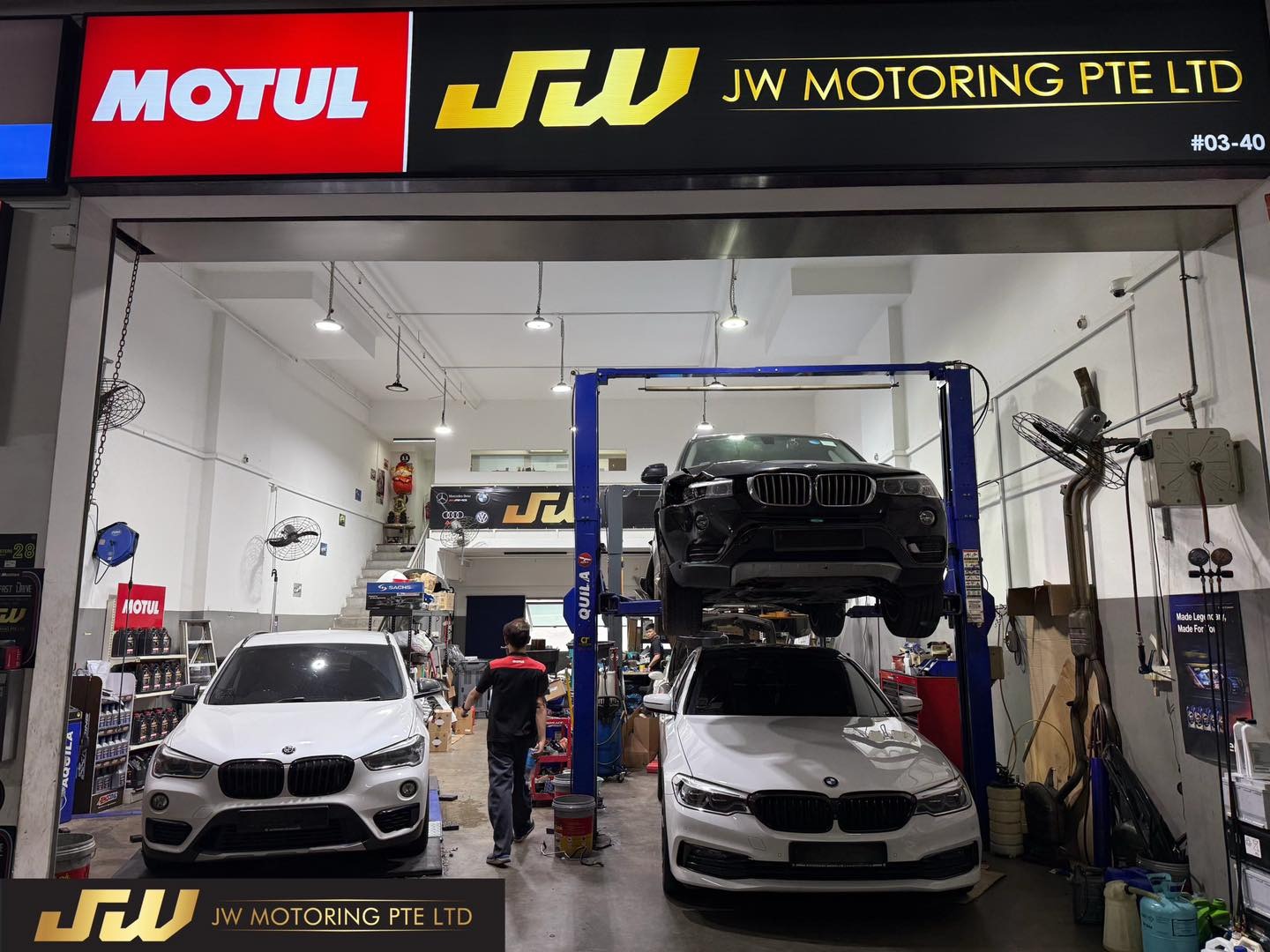 JW Motoring workshop with BMW vehicles on hydraulic lifts and Motul branding